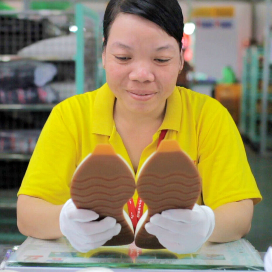 Factory worker inspecting shoe outsoles